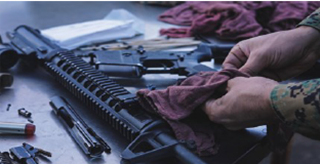 A Marine applying biobased CLP to a rifle.